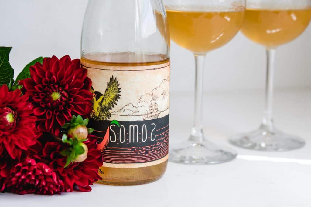 Somos Naranjito Verdehlo Wine Bottle and 2 glasses with red dahlia flowers