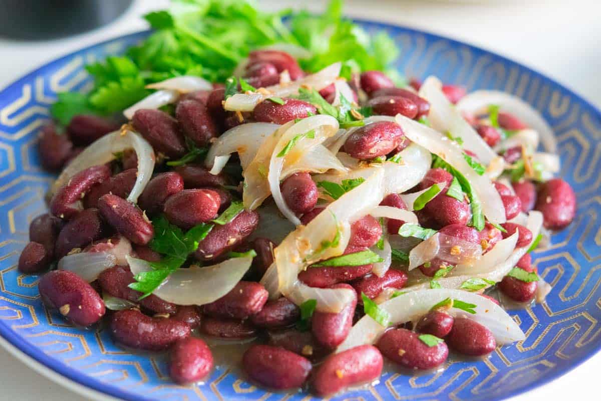 Ukrainian kidney bean salad on a blue and gold round plate