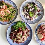 overhead shot of 4 Ukrainian salads on blue and gold round plates
