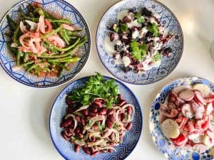 overhead shot of 4 Ukrainian salads on blue and gold round plates
