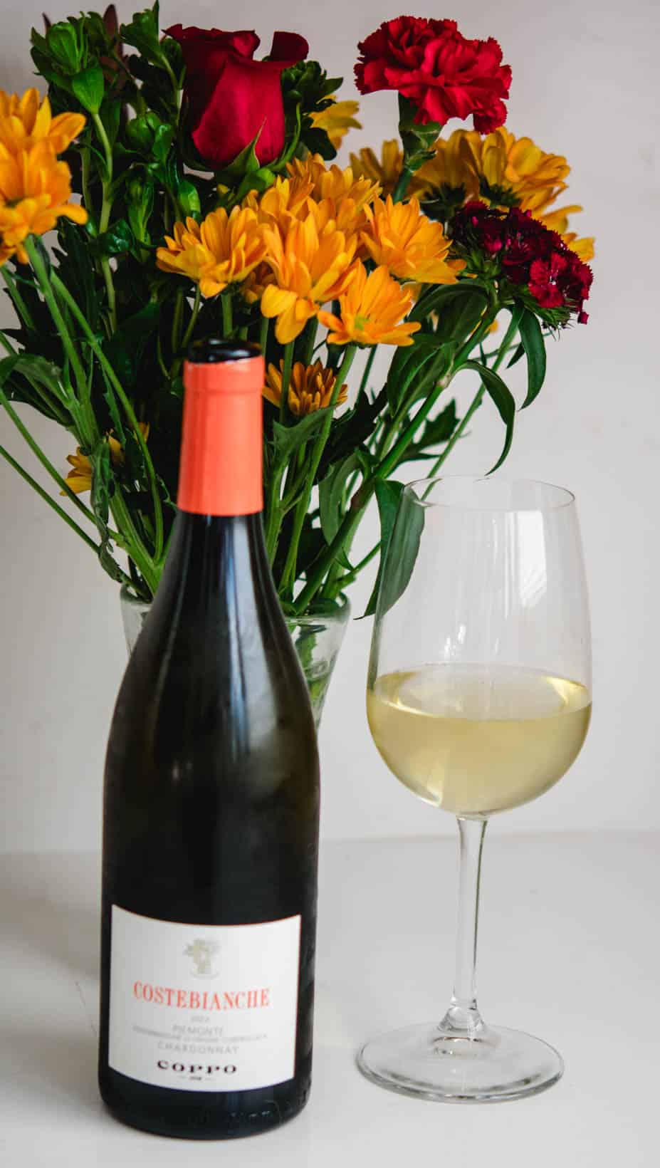 Glass and bottle of Costebianche Chardonnay wine from Coppo Wine